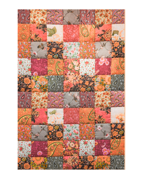 Patchwork quilt with floral and paisley patterns in various colors on a white background