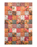 Patchwork quilt with floral and paisley patterns in various colors on a white background