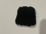 Black beaded mini bag on a white surface