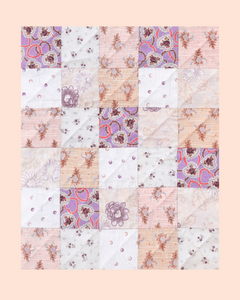 Patchwork quilt with floral patterns on a pastel background