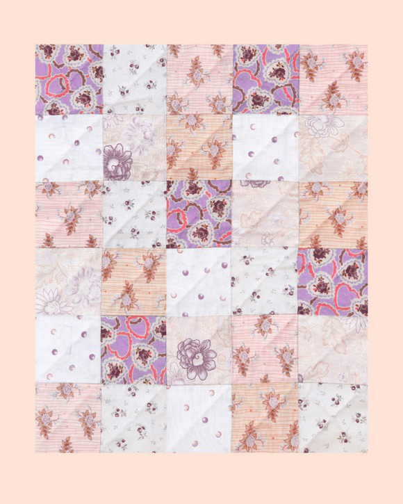 Patchwork quilt with floral patterns on a pastel background