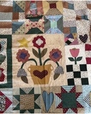Quilt with floral design and heart shapes in a patchwork pattern