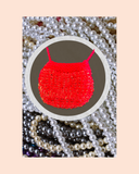 Red bead knitted necklace surrounded by peals with a pink background