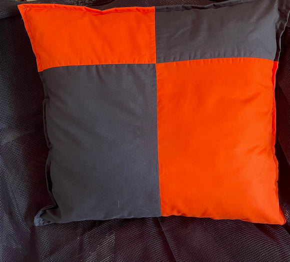 Pillow with orange and gray checkered pattern on a dark background