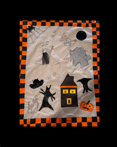 Halloween wall hanging why not make your own !!Halloween-themed decorative item with ghosts, pumpkins, and a house on a checkered border.