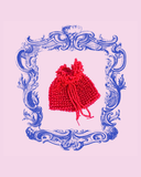 Red beaded pouch with a decorative blue frame on a pink background