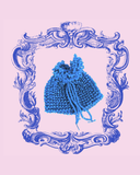 Blue knitted pouch bag with decorative frame on a pink background