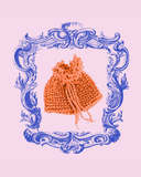 Decorative blue frame with a mandarin knitted item on a pink background