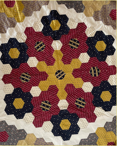 Hexagon Quilt pattern with floral designs in red, yellow, and blue on a white background