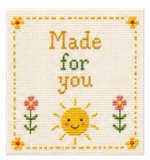 Cross-stitched design with a sun, flowers, and text 'Made for you' on a white background.