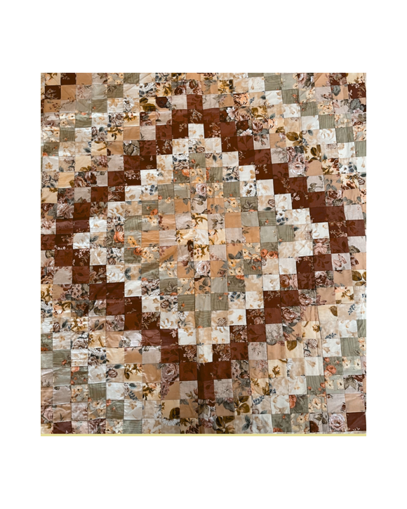 Patchwork quilt with multi-coloured square patterns on a white background