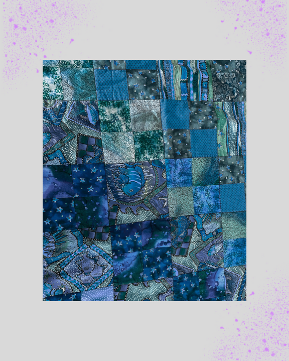 Patchwork quilt with blue and green patterns on a light purple background