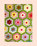 Colourful floral hexagon quilt pattern on a green background