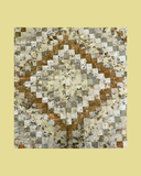 Patterned fabric patchwork quilt on a brown and grey background