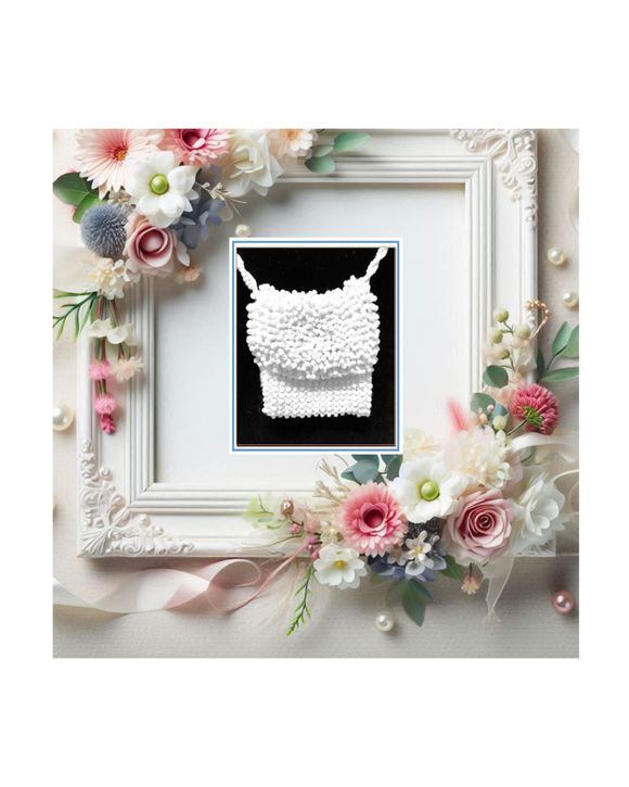 Decorative frame with wedding floral arrangement and a white beaded necklace on a black and white textured background
