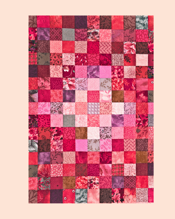 Patchwork quilt with a variety of pink and red patterns on a beige background