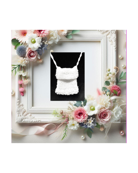 White beaded bag necklace displayed in a decorative wedding frame with bridal flowers on a white background