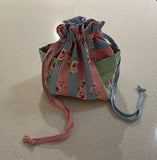 Fabric drawstring bag with floral pattern on a light surface