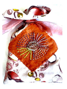 Decorative pouch with floral patterns and bead embellishments on a white background